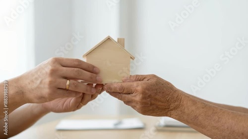 real estate agent senior clients concept. Real estate agent support senior clients handshake wooden house model trust care service concept guides home decision with caring hands holding small