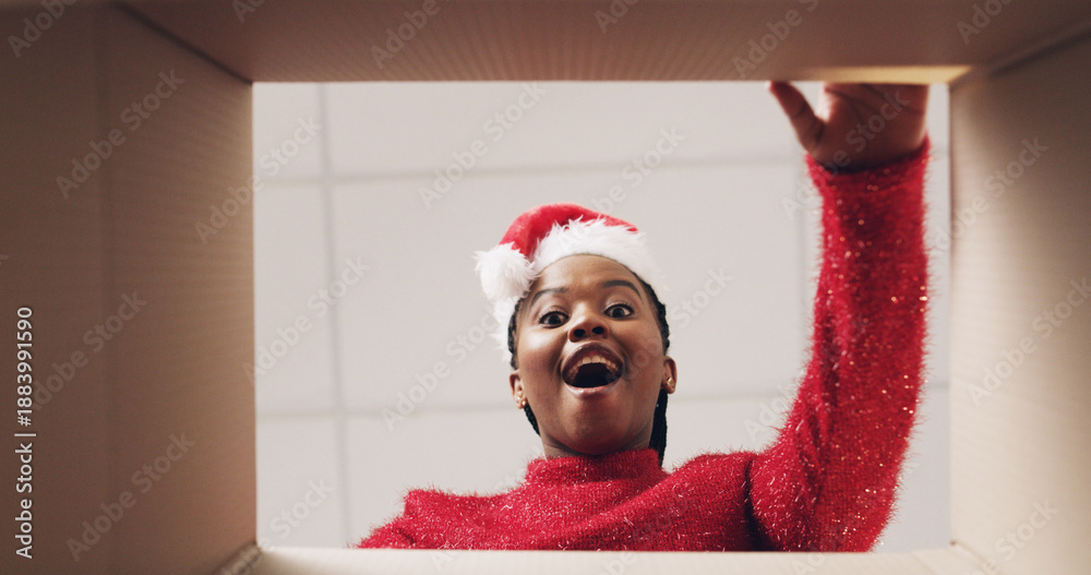 Fototapeta premium Christmas, box and pov of black woman with surprise for present, gift or package for festive season. Opening, below and portrait of person with parcel for shock, wow or omg for celebration or holiday