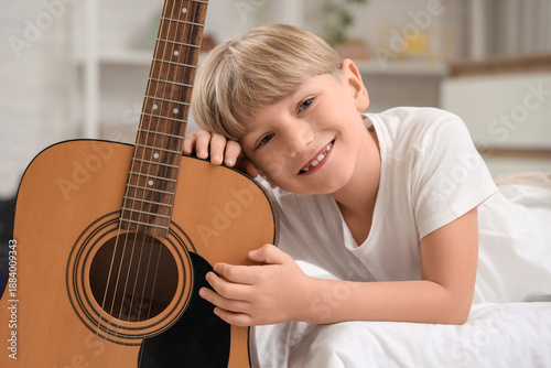 Little boy with guitar lyin...