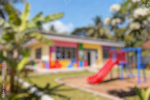 Wallpaper Mural Blurred preschool campus showing playground equipment beside bright educational building under clear blue sky daytime Torontodigital.ca