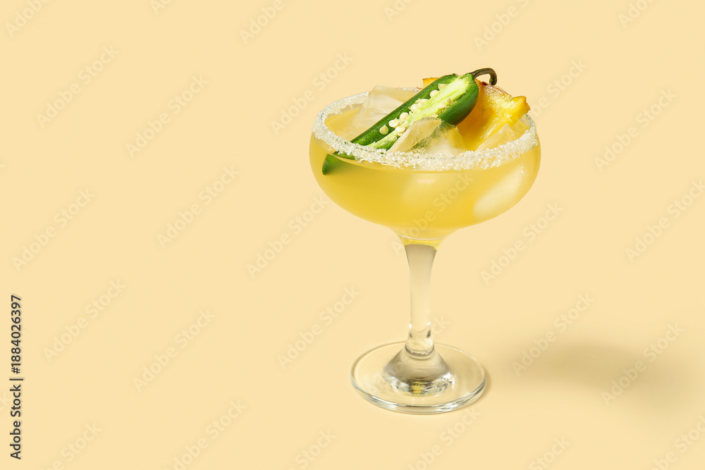 Fototapeta premium Glass of tasty margarita cocktail with jalapeno and pineapple on beige background