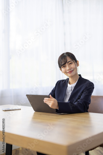 Bild auf Leinwand Smiling Young Businesswoman Using Tablet and Looking at Camera