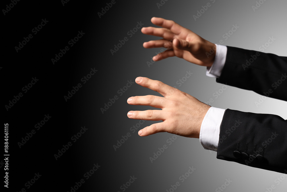 Obraz premium Hands of male conductor on dark background
