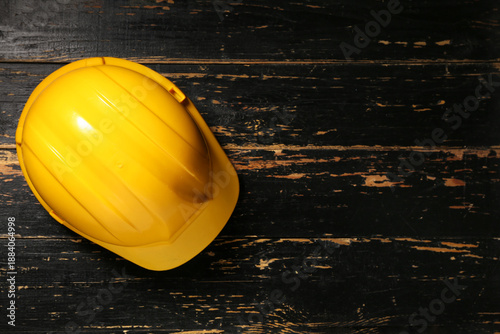 Yellow hardhat on wooden ba...