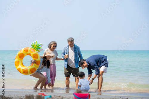 Multi-generational Asian family enjoying summer beach vacation together. Grandparents, parents, and child bonding by the sea, joyful outdoor. family, beach, vacation, summer, multi-generational.