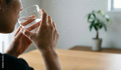 A man is drinking water from a glass.