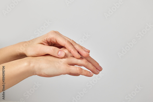 Female hands gently touching, symbolizing skin hydration, care, and wellness on a white background