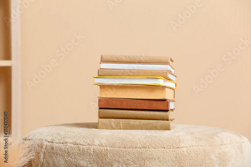 Konstfotografi Stack of books on pouf near color wall