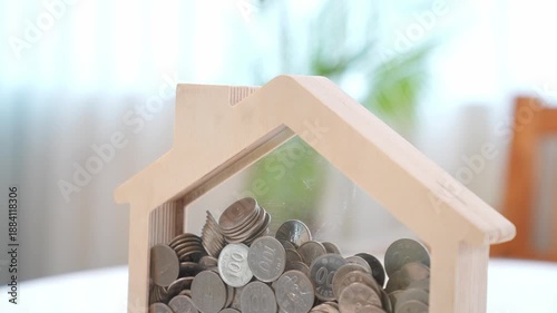 The Journey of Saving: Coin into a House Piggy Bank
