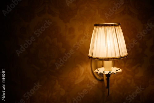Lantern with flame in retro style on the background of a stone wall of an ancient house.
