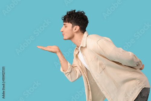 Handsome young man blowing ...