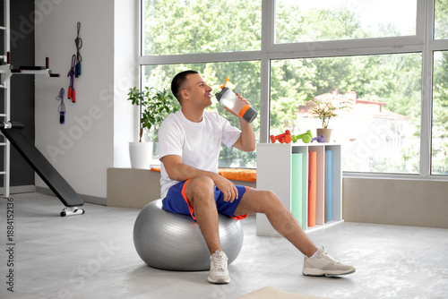 Sporty young man drinking w...