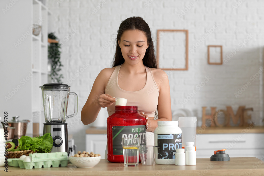 Fototapeta premium Sporty young happy Asian woman making protein shake at home