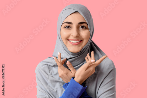 Portrait of happy Muslim woman on pink background