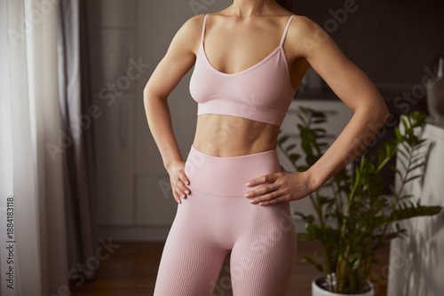 Unrecognizable fit woman demonstrating strength and poise in elegant pastel workout clothes, reflecting dedication and style. Ideal for fitness marketing and lifestyle branding.
