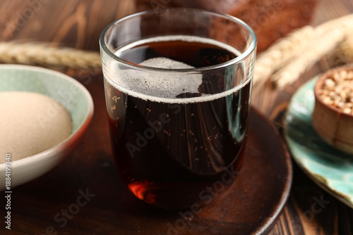 Glass of tasty kvass on table