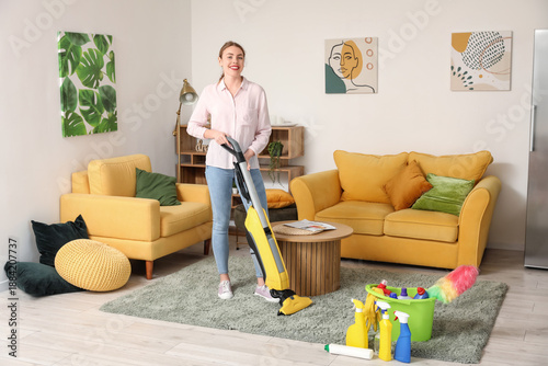 Young woman hoovering carpe...