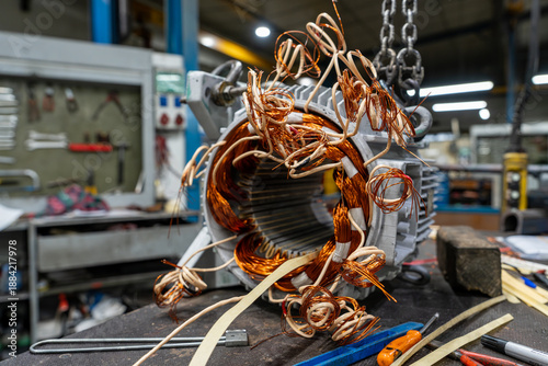 Foto Gros plan sur des bobinages en cuivre d’un moteur électrique en cours de réparation dans un atelier industriel, mettant en valeur la complexité des composants électromécaniques