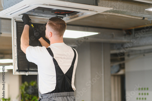 Εκτύπωση καμβά Hvac technician servicing commercial ceiling air conditioning unit
