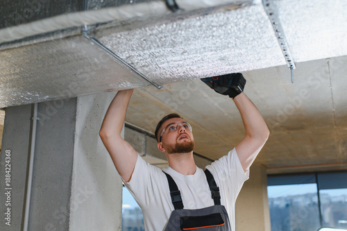 Canvas Print Hvac technician installing ventilation insulation on ceiling