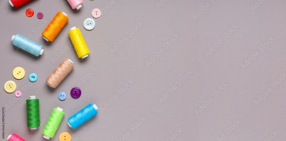 Naklejka premium Different thread spools and buttons on grey background with space for text