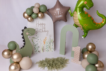 Dinosaur themed first birthday celebration background. Happy Birthday party decoration for a baby boy. Child one year old festive setup.