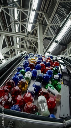 Wallpaper Mural High-angle video shot of a factory conveyor with colorful bottles, showcasing industrial efficiency under bright, structured lighting. Torontodigital.ca