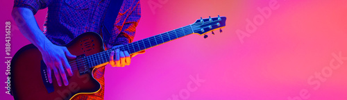 Fotografía Electric guitar player hands performing on colorful studio background
