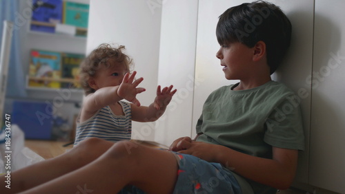 Photos Baby flinches and laughs nervously as older brother dangles plush keychain above
