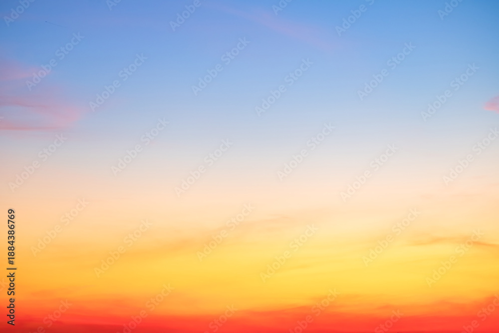 Obraz premium Sunset or sunrise sky with a vibrant gradient of orange, gold, and soft blue. Clear atmosphere with wispy clouds. Peaceful, natural light background. hope, freedom, new day and inspirational Concepts