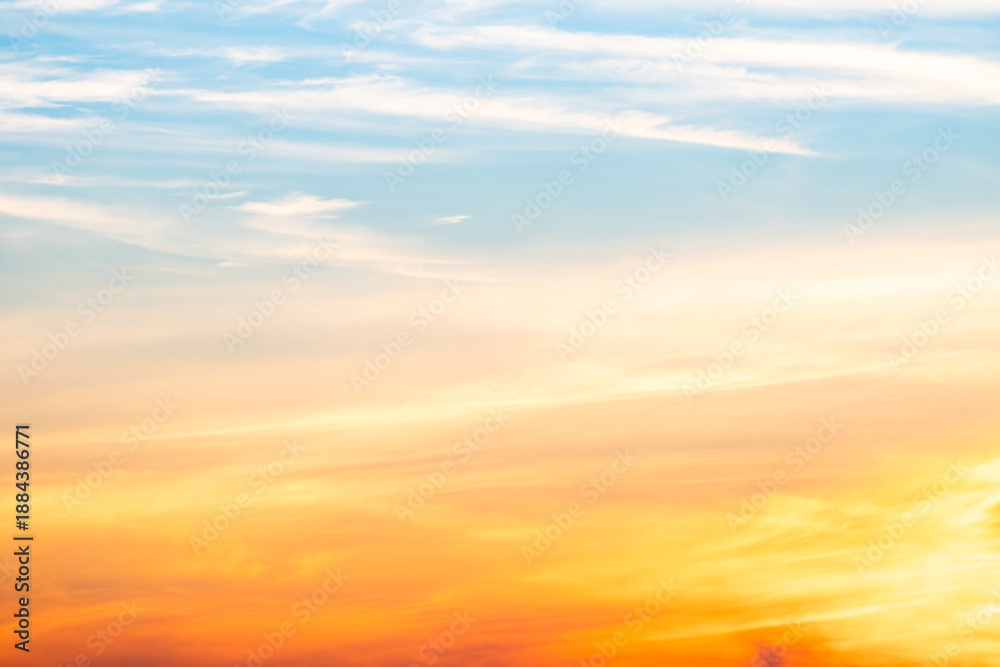 Obraz premium Sunset or sunrise sky with a vibrant gradient of orange, gold, and soft blue. Clear atmosphere with wispy clouds. Peaceful, natural light background. hope, freedom, new day and inspirational Concepts