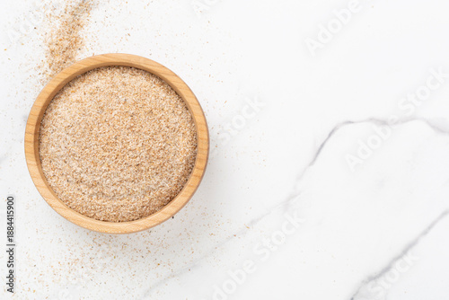 Foto Psyllium husk powder with fresh leaves on wooden background, top view