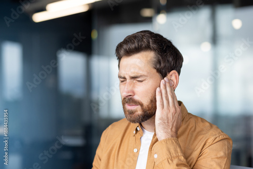 Schilderij op canvas Man clutching his ear in pain, showing severe earache and discomfort from infect
