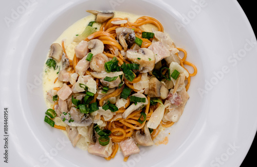 Pasta italiana gourmet servida en plato blanco sobre fondo negro