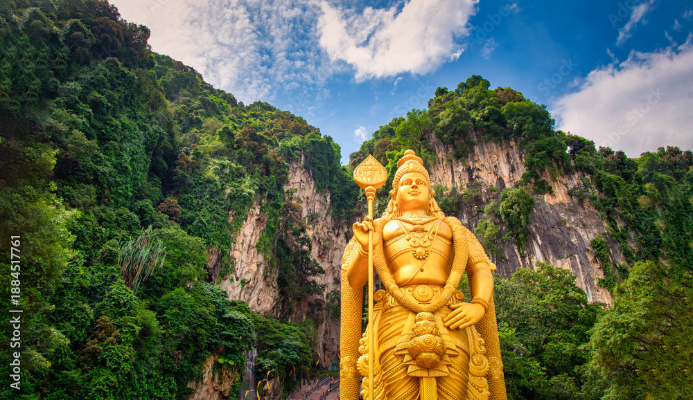 Fototapeta premium Statue of Lord Muragan and entrance with blue sky in Batu Caves, Kuala Lumpur, Malaysia.