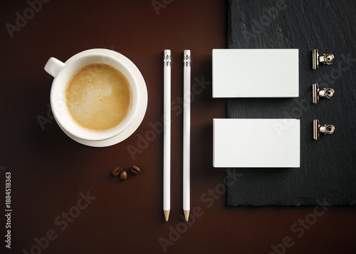 Blank stationery and coffee cup. Photo of blank business cards, pencils, coffee cup and binder clips. Flat lay.