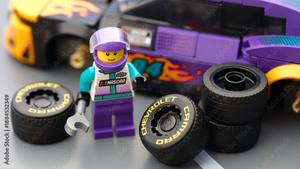 Fototapeta premium Tambov, Russian Federation - January 17, 2026 Lego driver minifigure with wrench ready to chang wheels on his Lego NASCAR Next Gen Chevrolet Camaro ZL car. LEGO Speed Champions.
