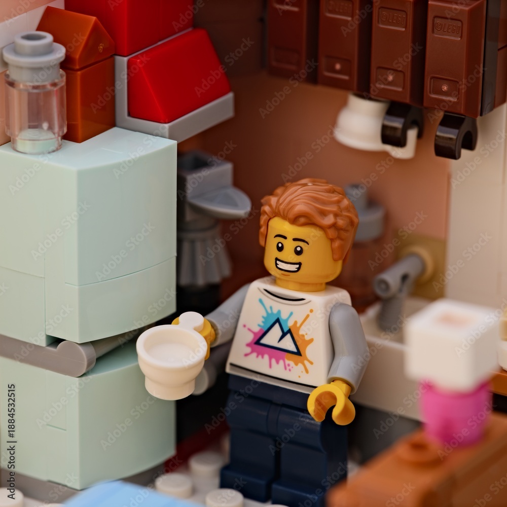 Obraz premium Tambov, Russian Federation - January 17, 2026 Lego man minifigure holding a white cup stands in a small kitchen.
