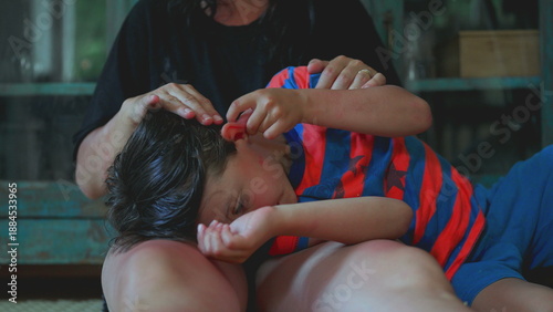 фотографія Child burying face in mother’s lap while being comforted with soft caress, quiet