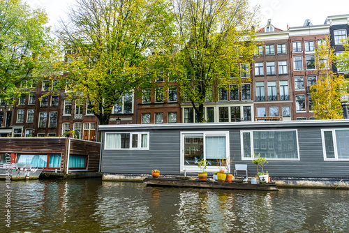 Photography Amsterdam Canal with Houseboat and traditional house Building.