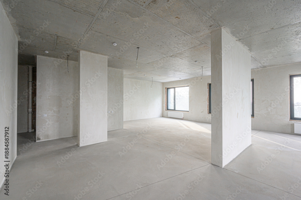 Obraz premium spacious pre-finished room with exposed concrete ceiling and floor, plastered walls, structural columns, three large windows, minimal fixtures, ready for interior design.