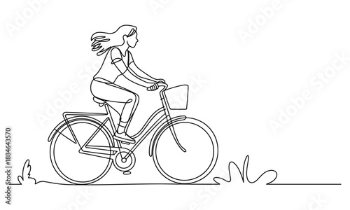 Woman riding a bicycle with wind in her hair and a basket