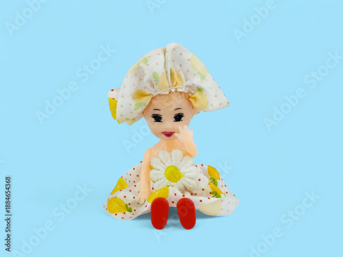фотографія Cute Little Toy Doll Sitting On Blue Background