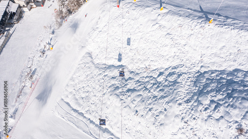 Aerial photo from dronet to Sierra Nevada ski resort on a sunny winter day in the mountains, Spain. Sierra Nevada is the largest mountain range near the city of Granada in Spain with snow. 
