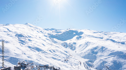 Aerial photo from dronet to Sierra Nevada ski resort on a sunny winter day in the mountains, Spain. Sierra Nevada is the largest mountain range near the city of Granada in Spain with snow. 