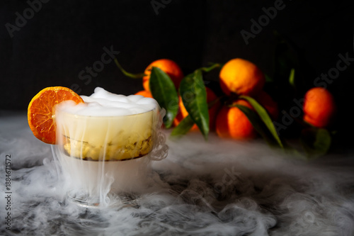 Creamy Orange Dessert in Glass with Dry Ice Smoke and Fresh Oranges in Background