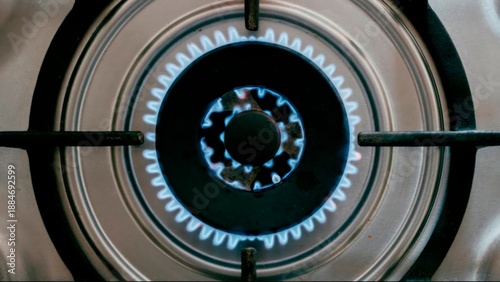 Gas stove burner with blue flame, kitchen appliance close up, energy and cooking concept, home kitchen detail, top view