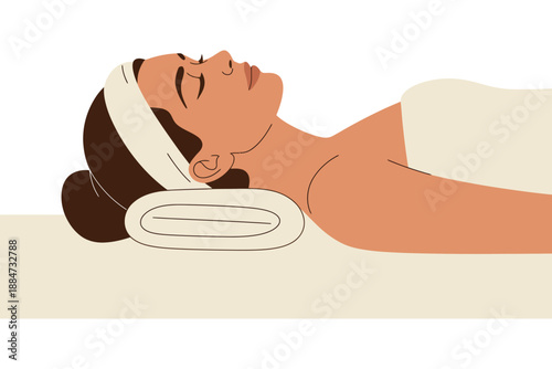 A serene woman lies on a spa bed with a towel on her head, relaxing during a facial treatment