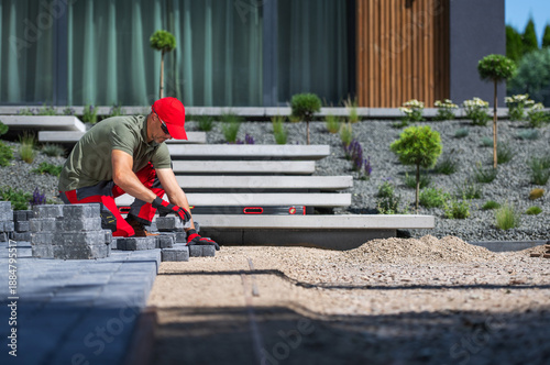 Man Laying Stones in Garden on Sunny Day Outside House