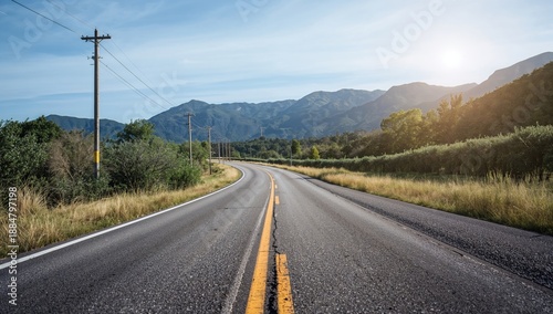 Road Winding Through Mountains Near Trees Under a Clear Sky in the Morning Light
